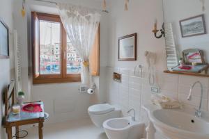 a bathroom with a toilet and a sink and a window at Residenza Mordini in La Maddalena