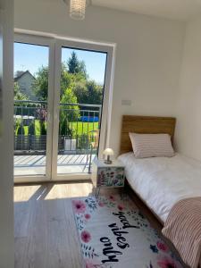 a bedroom with a bed and a large window at Apartament w Dolince Nowy Sącz in Nowy Sącz