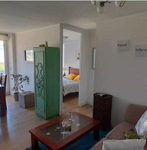 a living room with a green cabinet and a room with a bed at Apartment Lomas De Papudo in Papudo