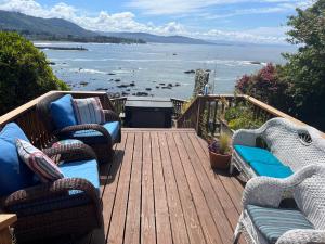 a deck with chairs and a view of the ocean at Mermaid's Muse Bed and Breakfast in Brookings