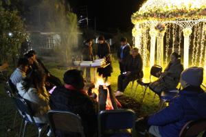 Eine Gruppe von Menschen, die nachts um ein Feuer herum sitzen in der Unterkunft Inkas Hotel y convenciones in Pisac