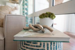 a table with a book and a plant on top of it at OCEAN VIEW DELUXE SUITE: PVT. BEACH & POOL in San Juan