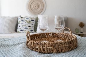two wine glasses and a basket on a bed at OCEAN VIEW DELUXE SUITE: PVT. BEACH & POOL in San Juan