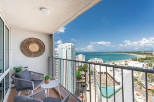 a balcony with a view of the beach and ocean at OCEAN VIEW DELUXE SUITE: PVT. BEACH & POOL in San Juan