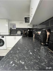 a large kitchen with a black counter top at Comfy Studio apartment with Wi-Fi and Smart TV in Leeds