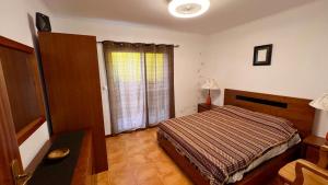 a bedroom with a bed and a desk and a window at Paraiso da Pedreira in Nordeste