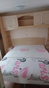 łóżko z biało-różową pościelą w obiekcie Le petit rio w mieście Noyelles-sur-Mer