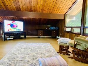 uma sala de estar com uma televisão de ecrã plano e um tapete em Happy Home Away em Victoria