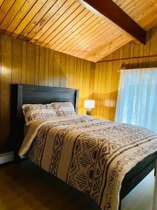 ein Schlafzimmer mit einem Bett und einer Holzwand in der Unterkunft Happy Home Away in Victoria