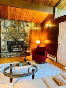 a living room with a stone fireplace and a red chair at Happy Home Away in Victoria