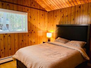 a bedroom with a large bed in a wooden wall at Happy Home Away in Victoria
