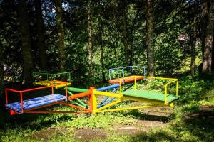 a group of colorful playground equipment in a forest at Ferienhaus Schetteregg in Egg