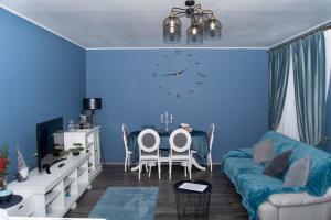 ein blaues Wohnzimmer mit einem Tisch und einem Sofa in der Unterkunft Casa Ary in Băile Olăneşti