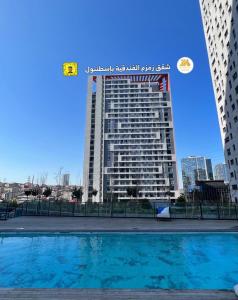 ein hohes Gebäude mit Pool davor in der Unterkunft ZamZam Suites Istanbul in Istanbul