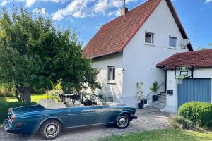 a blue car parked in front of a white house at Cosy Family Home in Tuningen +31 photos