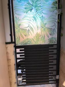 a metal door with a mural of palm trees at דירה נאה ומרווחת עם חצר פרטית in Netanya