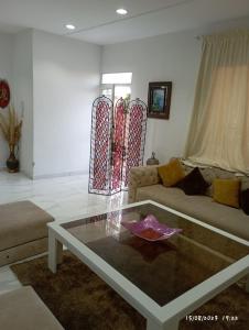 uma sala de estar com um sofá e uma mesa de vidro em Marrakech targa em Marrakech