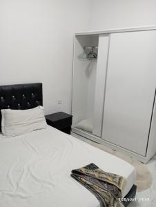 um quarto com uma cama branca e um espelho em Marrakech targa em Marrakech