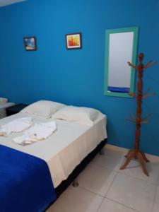 um quarto azul com uma cama e uma parede azul em Flat Porto dos Carneiros em Tamandaré