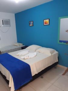 Flat Porto dos Carneiros في تامانداري: غرفة زرقاء مع سرير بجدار ازرق