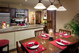 a kitchen and dining room with a wooden table with red napkins at Hyatt Vacation Club at Wild Oak Ranch in San Antonio