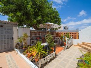 eine Terrasse mit einem Tisch, einem Sonnenschirm und Pflanzen in der Unterkunft Casa Las Tuneras, Solo Adultos in La Oliva