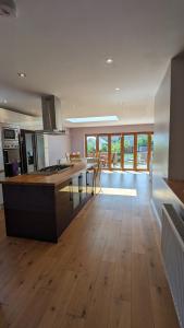 a large kitchen with a large island in a room at Cheltenham large house with gym, bar & hot tub in Golden Valley