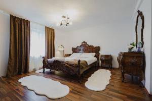 a bedroom with a bed and two white rugs at CASA BARONULUI in Baia Mare