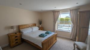 una camera da letto con un letto e una grande finestra di Cheltenham large house with gym, bar & hot tub a Golden Valley