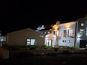 a large house at night with its lights on at 6 on Third in Stompneusbaai