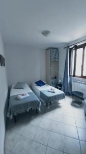 dwa łóżka w pokoju z dwoma oknami w obiekcie Casa vacanza Luna w mieście Orte