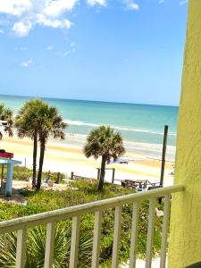 a view of a beach with palm trees and the ocean at Waters Edge - Ocean View at Symphony Beach Club in Ormond Beach
