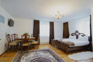 a bedroom with a bed and a table and chairs at CASA BARONULUI in Baia Mare