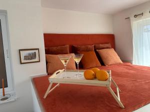 a bed with two glasses of champagne and oranges on a tray at DoMiSol duplex suites near sea in St. Paul's Bay