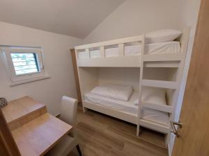 a room with a bunk bed with white bunk beds at Gostilna in pizzeria Pri Brajdi in Komen