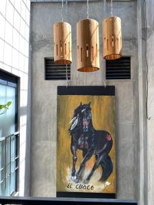 a painting of a black horse on a wall with lights at Casa Conicarit in Puerto Escondido