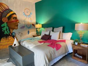 1 dormitorio con 1 cama y una pintura de una mujer en Casa Conicarit, en Puerto Escondido