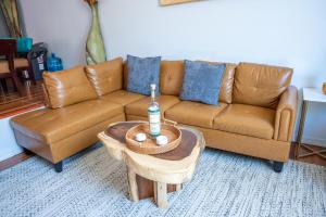 ein Wohnzimmer mit einem braunen Sofa und einem Tisch in der Unterkunft Casa Roja - 1block2beach - Las Playas in Tijuana