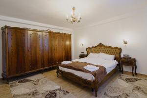 a bedroom with a bed with wooden furniture and a chandelier at CASA BARONULUI in Baia Mare