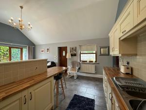 uma cozinha com armários brancos e uma bancada em The Red Lodge Annexe em Woodborough
