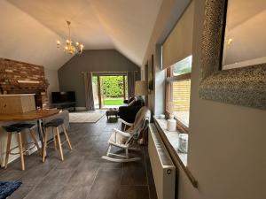 a kitchen and living room with a table and chairs at The Red Lodge Annexe in Woodborough