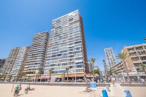 ベニドルムにあるLos Gemelos 21-B Apartment Levante Beachの浜辺のヤシの木が茂る大きな建物
