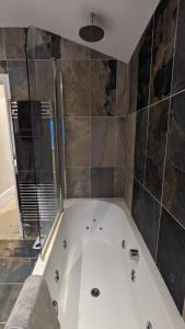 e bagno con vasca e doccia. di Cheltenham large house with gym, bar & hot tub a Golden Valley Altre 42 foto