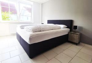 sypialnia z dużym łóżkiem z białą pościelą i oknem w obiekcie Ferienwohnung MarLeo w mieście Affoldern