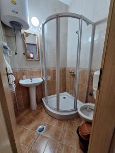 een badkamer met een douche, een toilet en een wastafel bij Studio Apartments Oleg Ohrid in Ohrid