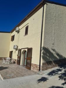 a building with a brown door and a patio at Agriturismo Cara Terra Lucana in Chiaromonte