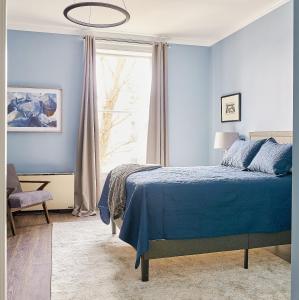 a blue bedroom with a bed and a window at The Stockade Inn in Schenectady