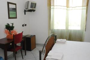 sypialnia z łóżkiem, biurkiem i telewizorem w obiekcie B&B Martius 2 w mieście Martano