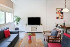 a living room with a couch and a tv at Great 2BR in Lassale street by HolyGuest in Tel Aviv