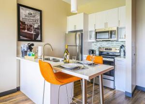 une cuisine avec une table, des chaises orange et des appareils électroménagers dans l'établissement Private Downtown Apartment With Garage Parking, à Raleigh